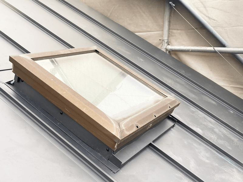 天窓まわり役物取付・立平葺き板金加工施工している様子