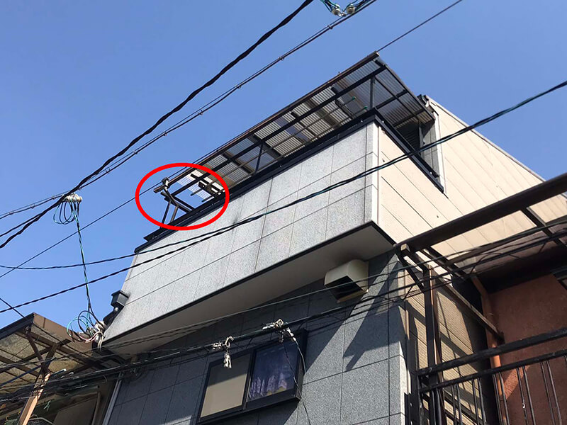 台風の強風で3階ベランダの波板が飛散し、骨組みだけが残った状態の施工前写真