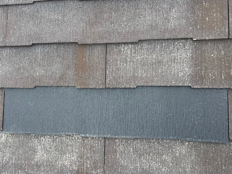 新しい屋根材をコーキングで差し込み補修している様子