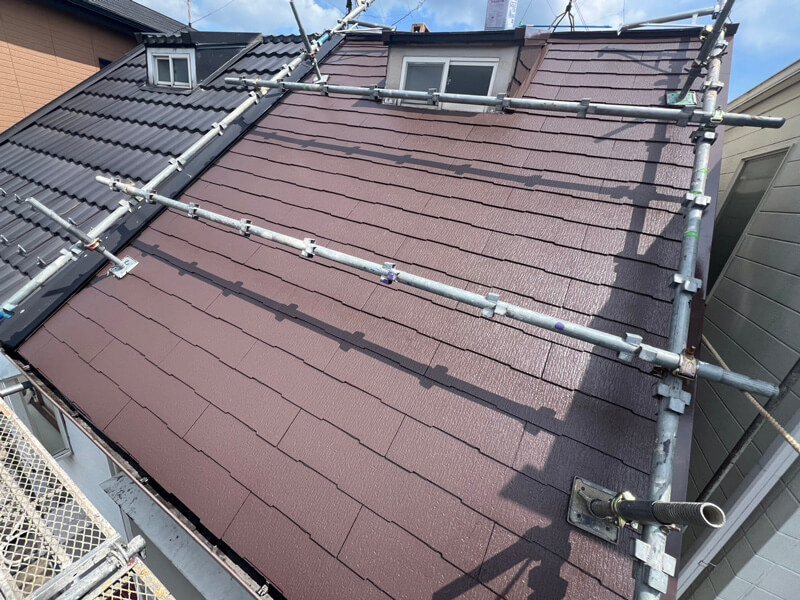 屋根中塗り工程で塗料を均一に塗布している様子