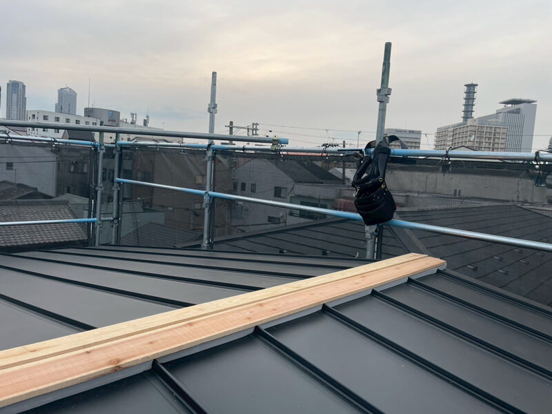 棟部分に貫板を取り付けて棟板金下地を施工している様子
