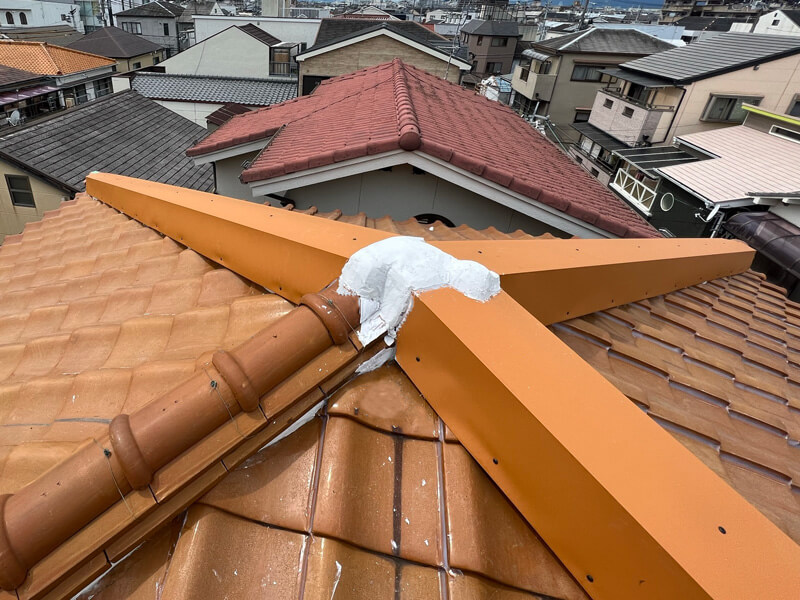 瓦棟への特注オレンジ板金カバー工事完了の写真