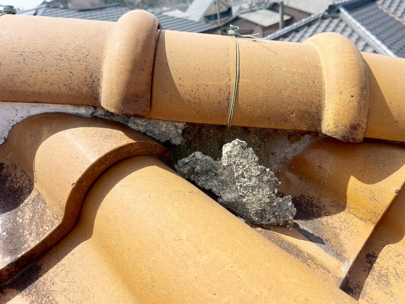 棟漆喰が劣化して割れ・土が流出しているS型瓦屋根の写真