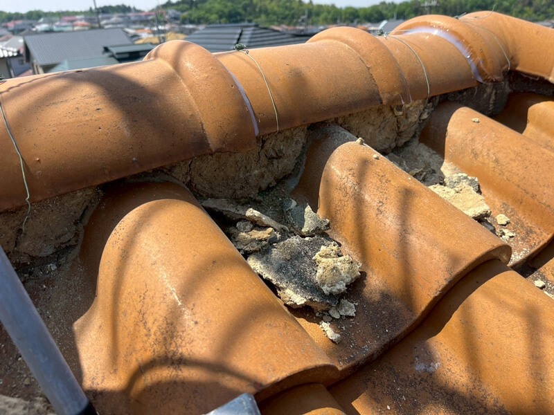 棟の劣化した漆喰を撤去している様子の写真