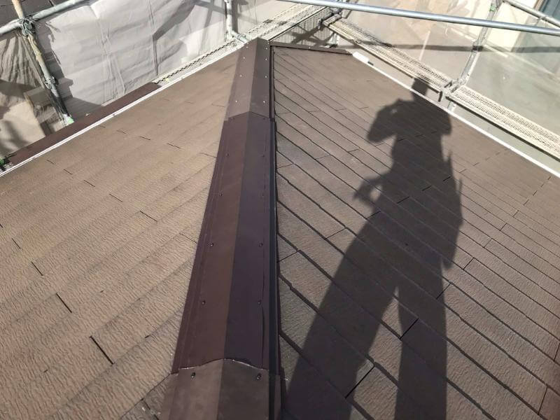 足場を組んで急勾配のコロニアル屋根の棟板金を交換した施工後の写真