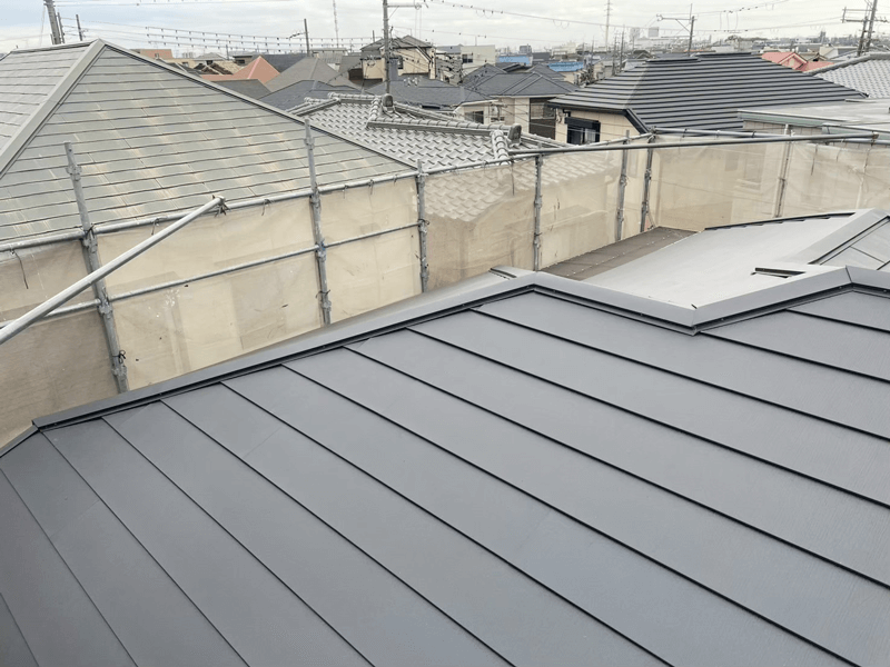 スーパーガルテクト屋根材の拡大・完成後施工写真 まとめ このたびは屋根カバー工法および外壁塗装工事のご依頼をいただき、誠にありがとうございました。築37年という節目に、屋根・外壁をまとめてリニューアルできたことで、今後も長く安心してお住まいいただける状態に仕上げることができました。複数社をご比較のうえ当社をお選びいただいたことを、大変嬉しく思っております。 今回採用した「スーパーガルテクト」は、錆びに強いガルバリウム鋼板に断熱材を一体成形した屋根材で、防水性・耐候性に優れるだけでなく、夏の遮熱・冬の保温効果も期待できる素材です。また既存のカラーベストを撤去せずに上から被せるカバー工法のため、廃材の発生を抑えながら工期を短縮できるのもメリットのひとつです。外壁塗装と足場を共有したことで、別々に発注するよりもトータルコストを抑えることができました。 屋根工事には15年保証をお付けしておりますので、万が一の際もご安心ください。定期点検にも対応しておりますので、保証期間中はもちろん、その後も気になる点があればいつでもお声がけください。「必要な工事だけをご提案する」という姿勢は今後も変わりません。 カラーベスト屋根は表面のひび割れが目立ち始めたころが、塗装かカバー工法かを検討する最適なタイミングです。「まだ大丈夫だろう」と先延ばしにしてしまうと、下地まで傷みが進んで修繕の選択肢が狭まることもあります。屋根のご状態が気になりましたら、ぜひお気軽にご相談ください。築37年の屋根・外壁を同時リニューアル｜スーパーガルテクトカバー工法工事 これに外壁塗装も入れて13:41築37年の屋根・外壁を同時リニューアル｜スーパーガルテクトカバー工法・外壁塗装工事