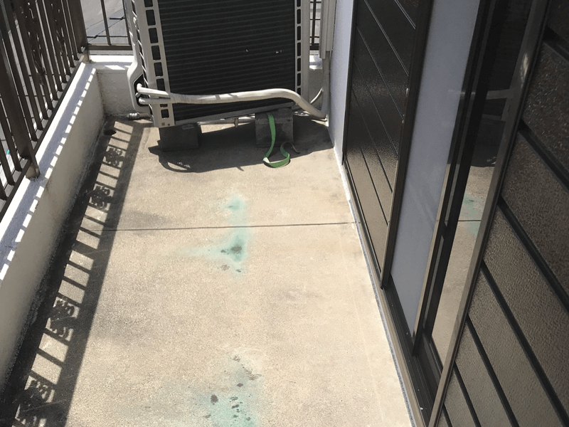 ベランダ床を高圧洗浄前に清掃している様子