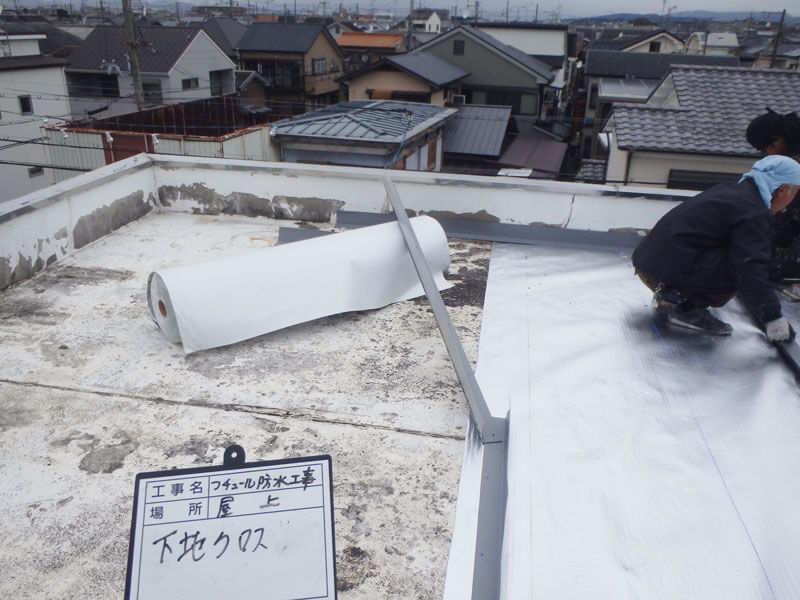 屋上防水下地クロス貼り付けしている様子