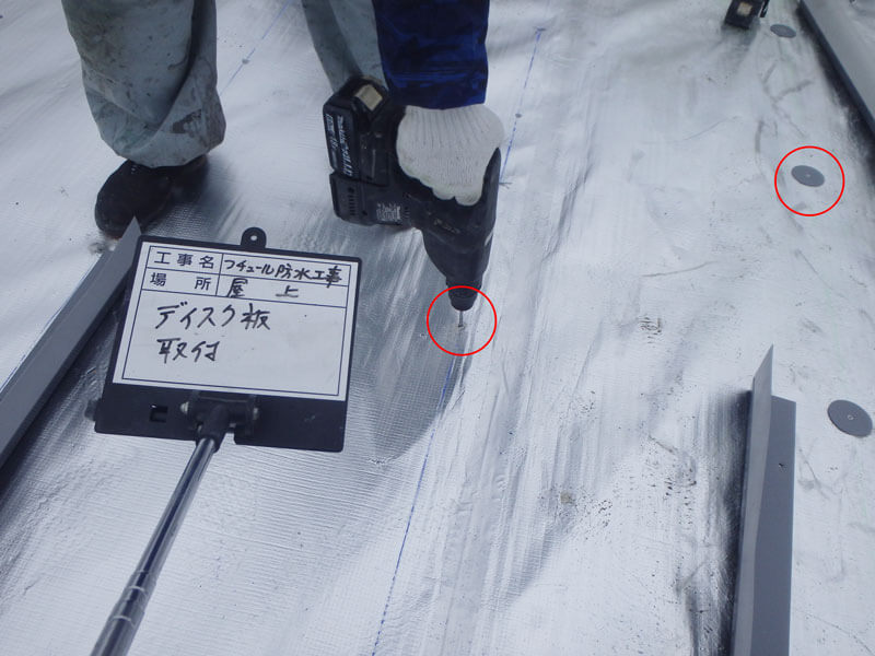 屋上ディスク板機械固定・穴あけしている様子