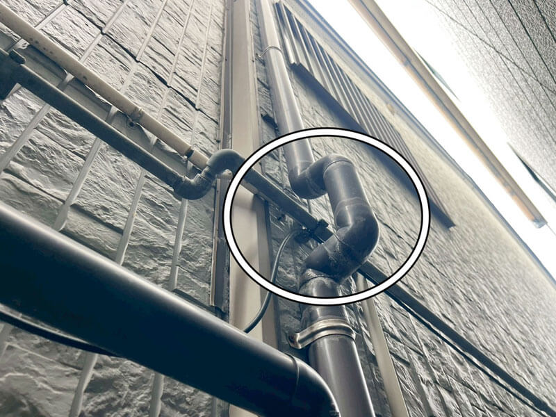 竪樋L字エルボ部分に土砂が堆積している写真