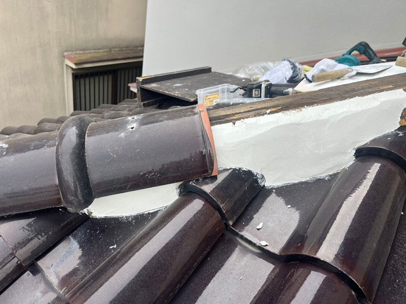 棟を解体してS瓦下屋根の漆喰を上部まで施工している様子