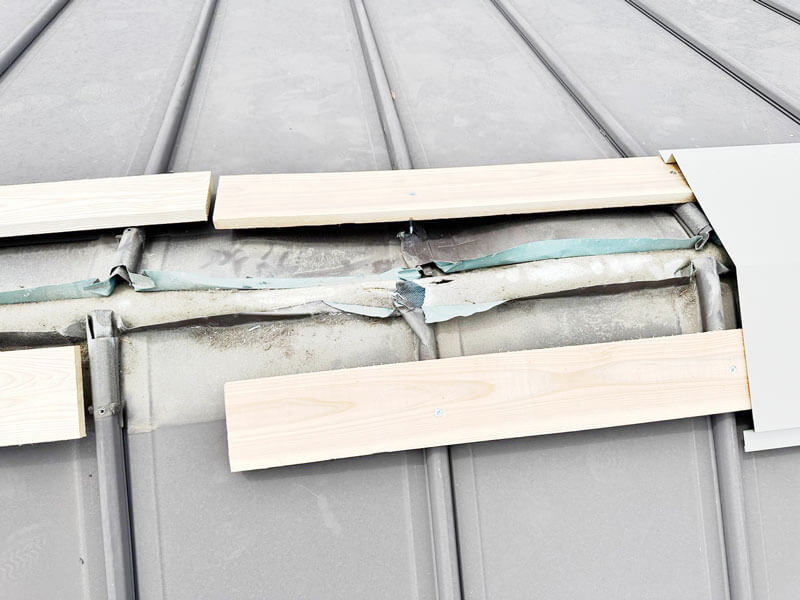 立平屋根の修理中に特注棟の貫板を新設している施工中の写真