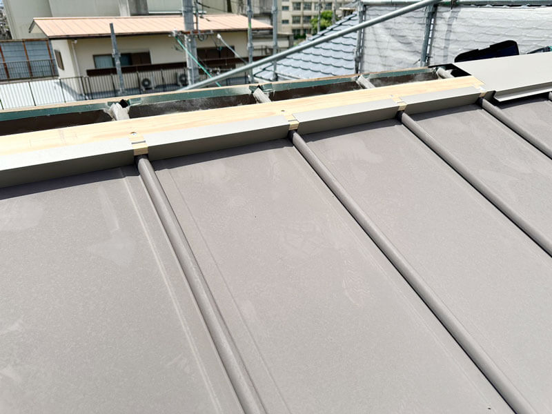 立平屋根の面土部分にスカートを設置し雨水吹き込みを防止している施工中の写真