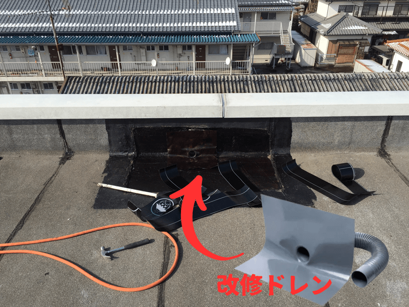 既存ドレンに改修ドレンを設置して排水経路を確保している様子