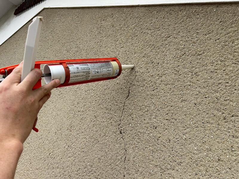 外壁クラック（ひび割れ）コーキング補修施工している様子