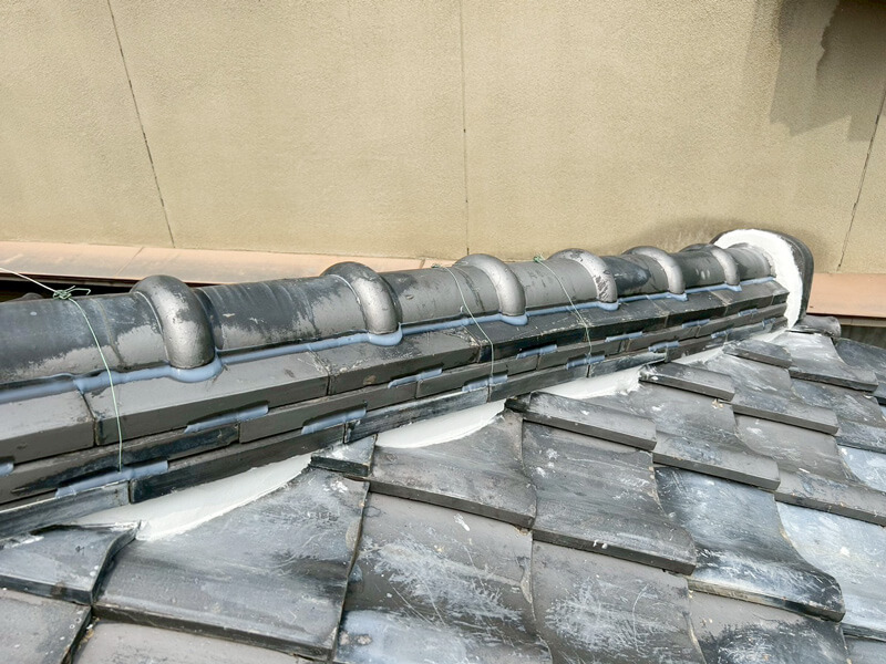 下屋根（1階屋根）棟瓦・鬼瓦漆喰補修完了後の写真