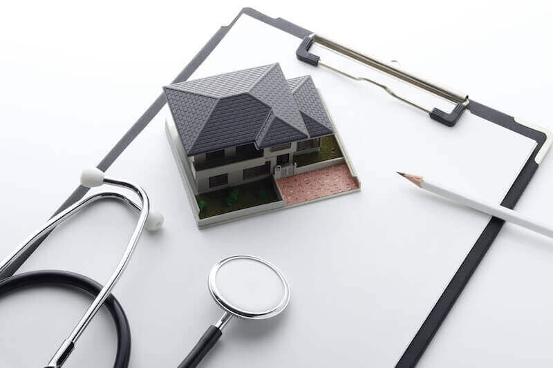 住宅点検や診断をイメージした家の模型と聴診器の写真。