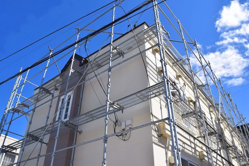 外壁塗装や屋根工事のために住宅全体に設置された足場の写真。