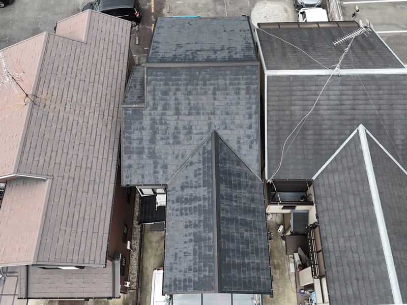 ドローンで上空から撮影したコロニアル屋根。塗装不良による塗膜の剥がれやムラが広がっている状態。