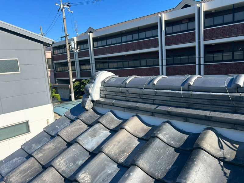 鬼瓦の接点に新しい漆喰を充填し雨仕舞いを整えた施工後の瓦屋根。